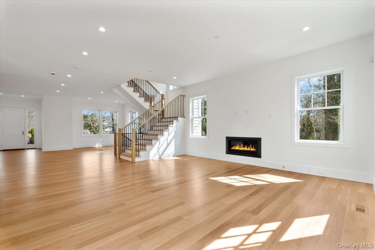 8 Dell Road Scarsdale, NY 10583 - Photo 9 of 41 a view of an empty room with wooden floor fireplace and windows