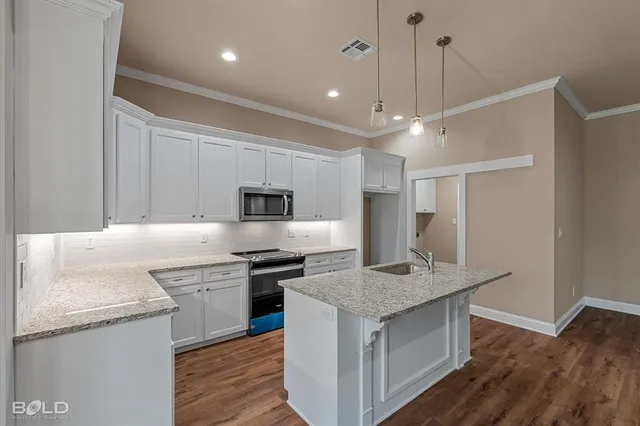 a kitchen with stainless steel appliances granite countertop a sink stove and refrigerator