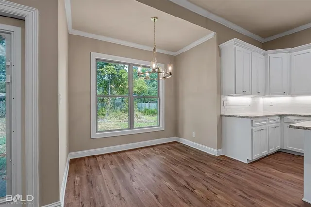 a kitchen with a sink window and wooden floor