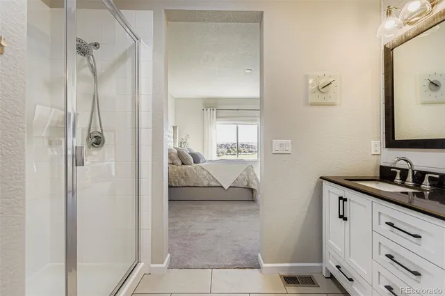 a en suite bathroom with a double vanity sink a mirror and shower