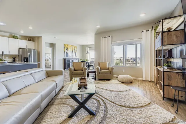 a living room with furniture a rug and a large window