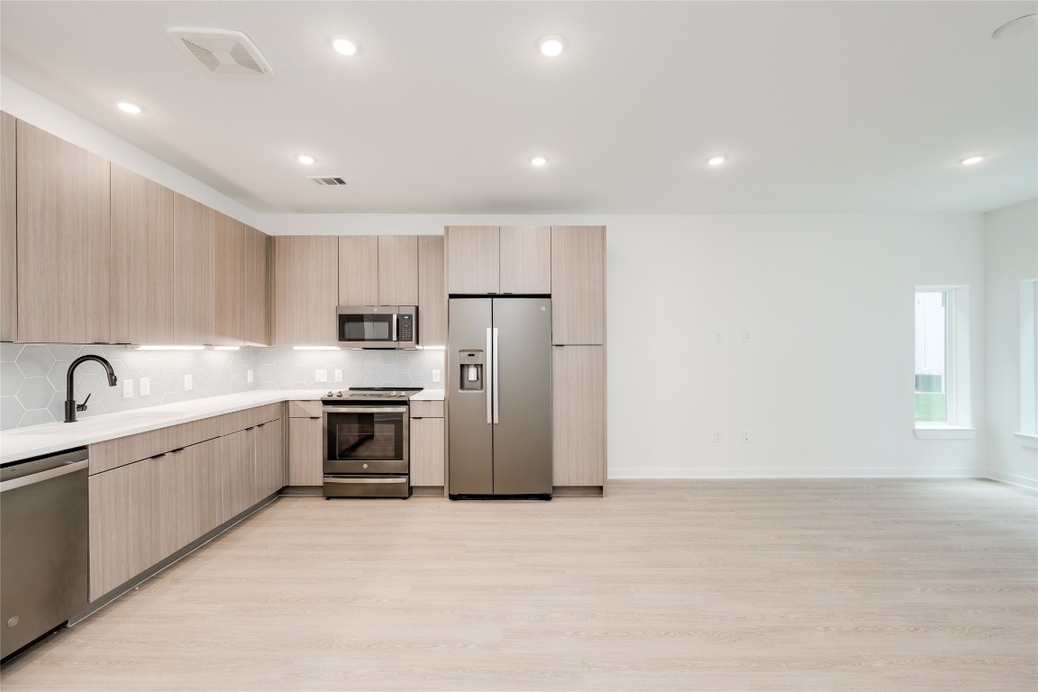 4802 South Congress Avenue, Unit 121 Austin, TX 78745 - Photo 8 of 38 a large kitchen with stainless steel appliances granite countertop a stove a sink and a refrigerator
