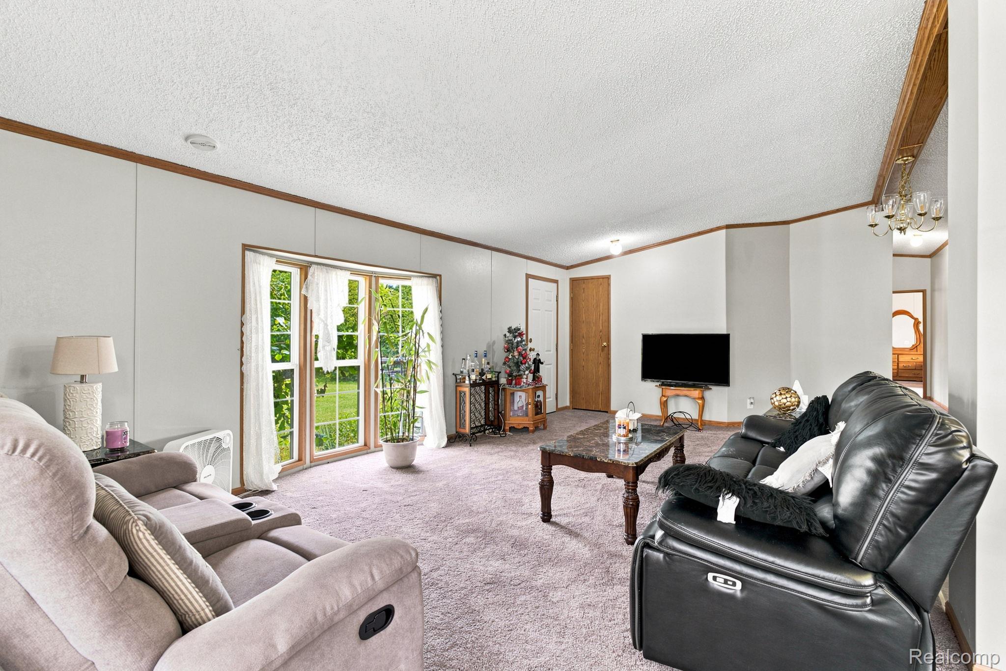 Neutral-toned wall paneling with wood-finish trim, textured ceiling, and light-toned carpeting