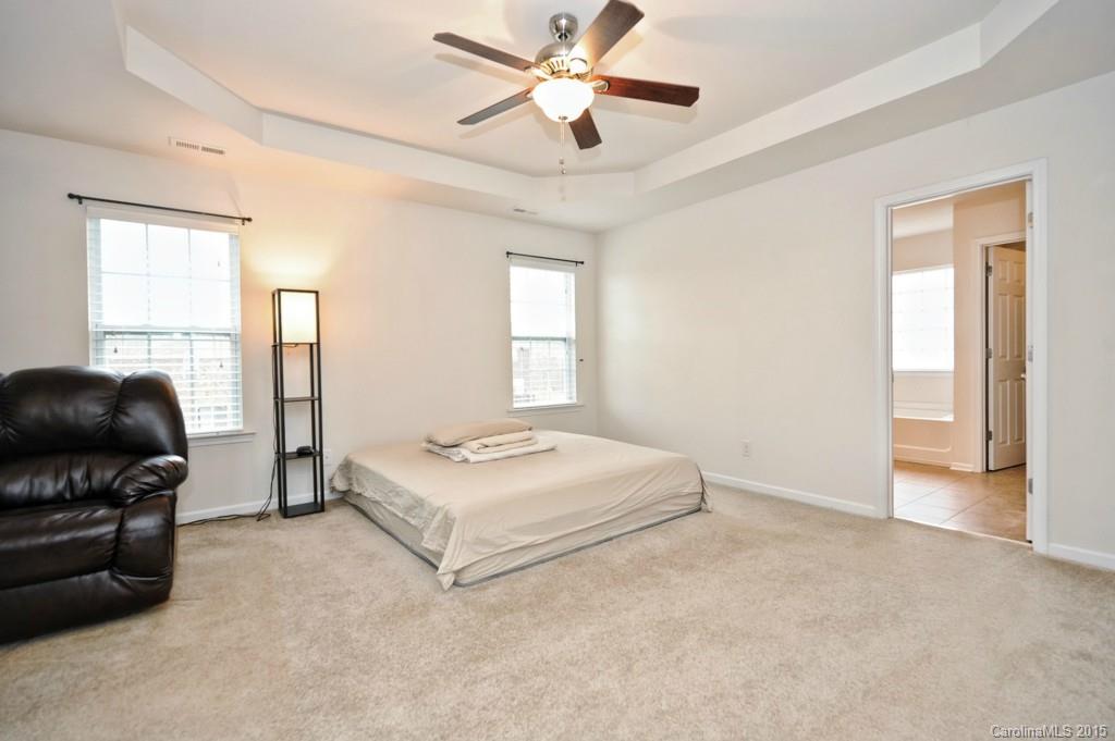 9927 Paxton Run Road Charlotte, NC 28277 - Photo 13 of 24 a bedroom with a bed and a chandelier