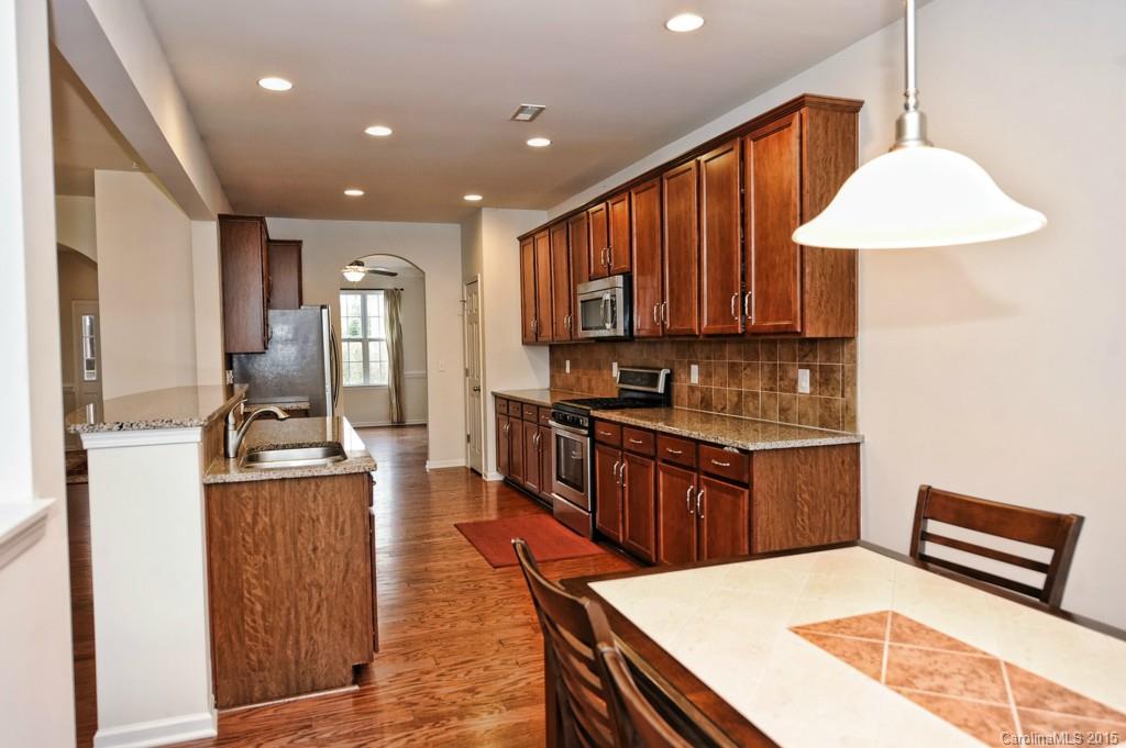 9927 Paxton Run Road Charlotte, NC 28277 - Photo 5 of 24 a kitchen with stainless steel appliances granite countertop a refrigerator a stove top oven a sink dishwasher and wooden cabinets