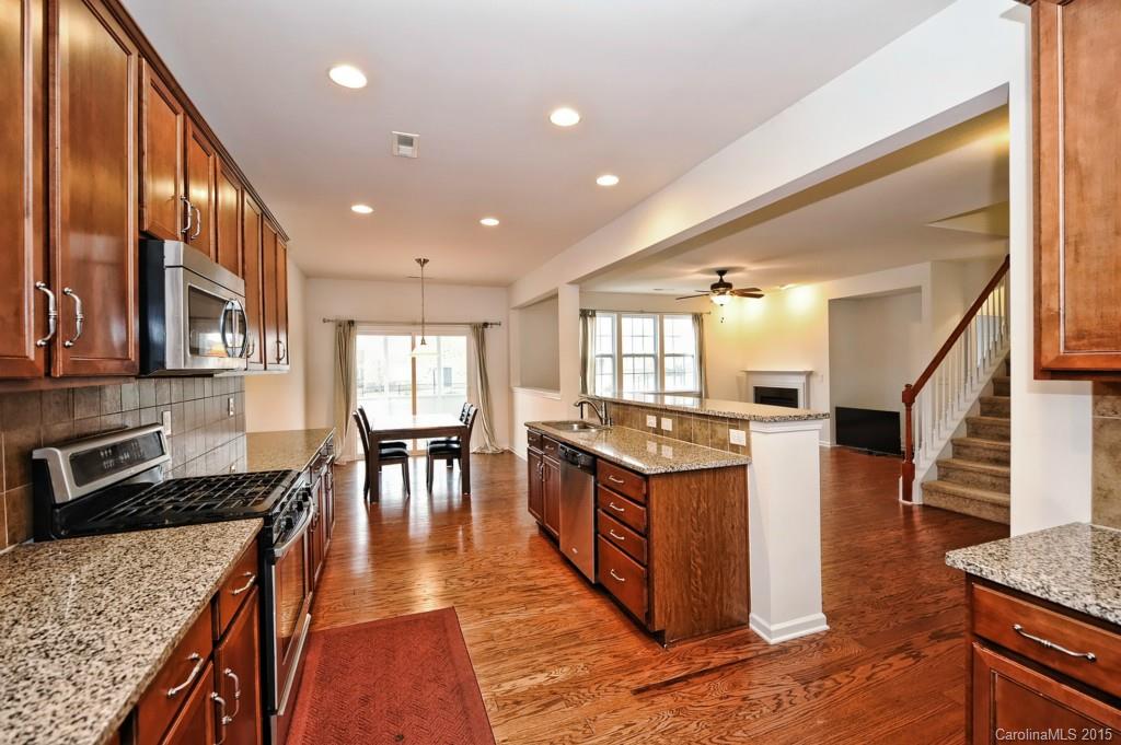 9927 Paxton Run Road Charlotte, NC 28277 - Photo 7 of 24 a large kitchen with stainless steel appliances granite countertop a stove and a view of living room