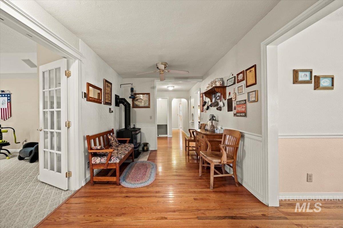 7425 Robinson Road Kuna, ID 83634 - Photo 15 of 50 Hall with arched walkways, light wood-style floors, and wainscoting
