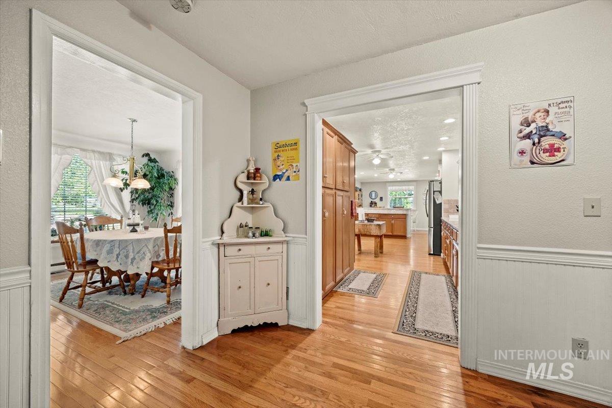 7425 Robinson Road Kuna, ID 83634 - Photo 16 of 50 Corridor featuring light wood finished floors, a wainscoted wall, plenty of natural light, and a textured ceiling