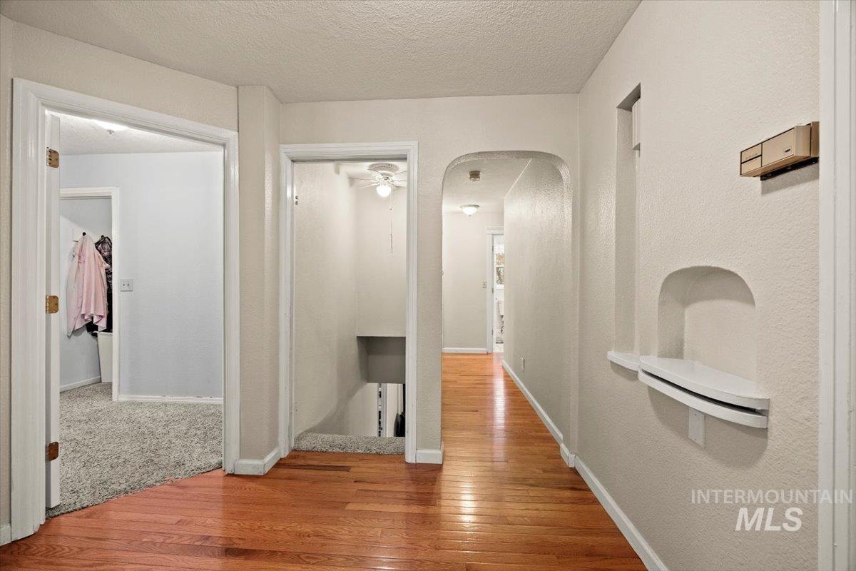 7425 Robinson Road Kuna, ID 83634 - Photo 29 of 50 Hallway featuring hardwood / wood-style floors, arched walkways, and a textured ceiling