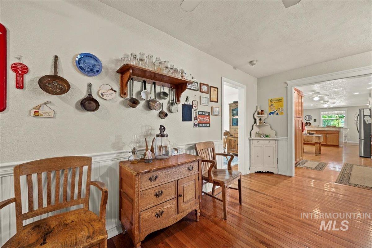 7425 Robinson Road Kuna, ID 83634 - Photo 34 of 50 Living area featuring a textured ceiling, wood finished floors, and wainscoting