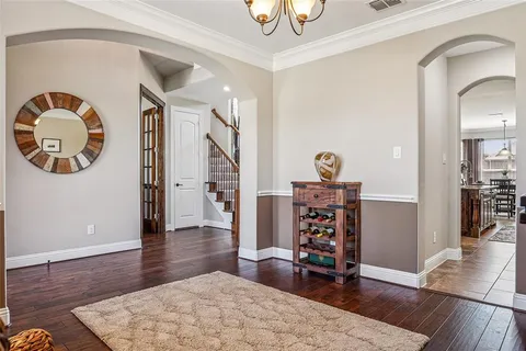 a view of a hallway with wooden floor and furniture