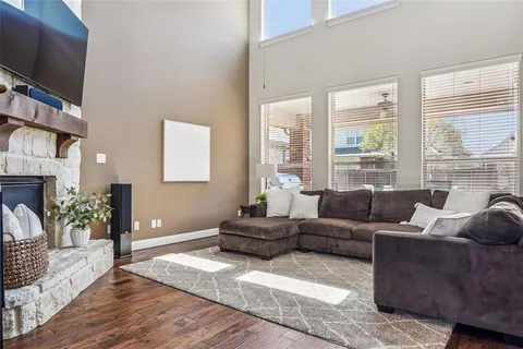 a living room with furniture a flat screen tv and a large window