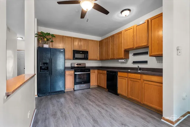 a kitchen with stainless steel appliances granite countertop a refrigerator a sink dishwasher a stove and a microwave oven with cabinets