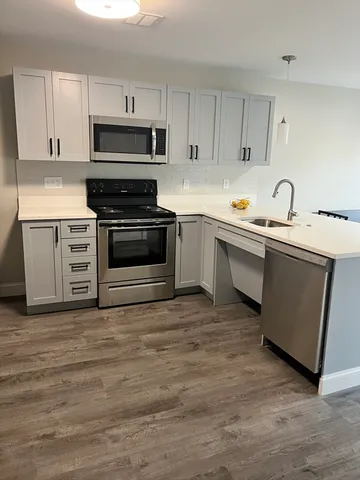 a kitchen with sink a microwave and cabinets