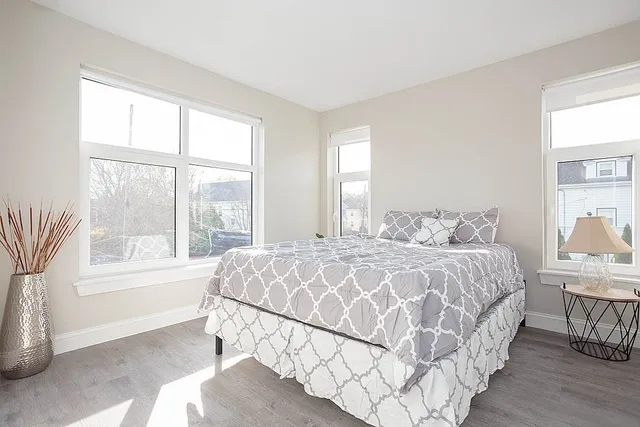 a large bed sitting in a bedroom next to a window