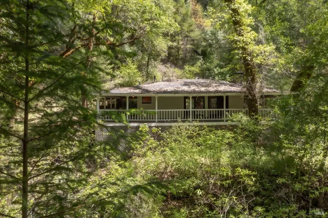 an aerial view of residential house with space and trees all around