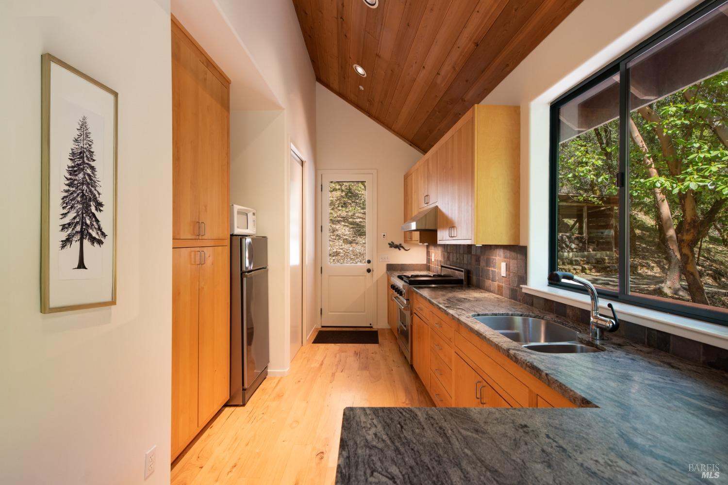 16300-16333 Yerba Santa Road Geyserville, CA 95441 - Photo 10 of 35 a large kitchen with stainless steel appliances granite countertop a refrigerator a sink dishwasher and wooden cabinets with wooden floor