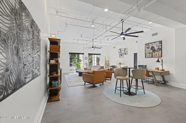 a living room with furniture kitchen view and a window