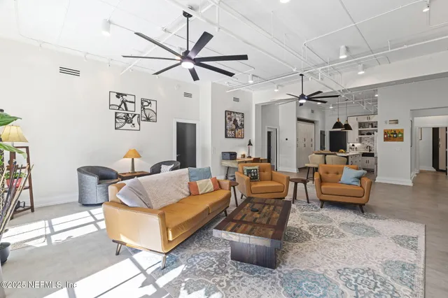 a kitchen with stainless steel appliances a refrigerator a sink dishwasher a stove and a dining table with wooden floor