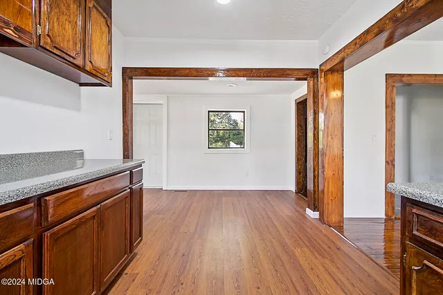 a view of a kitchen with wooden floor and a window