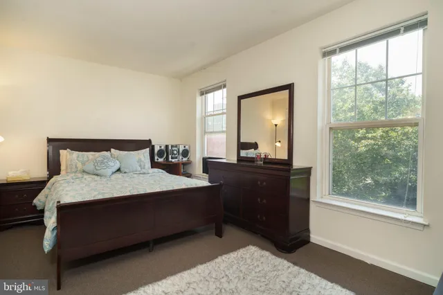 a bedroom with a bed and a large window