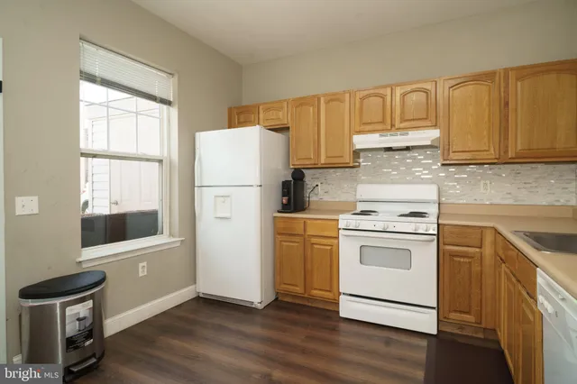 a kitchen with white cabinets and white appliances