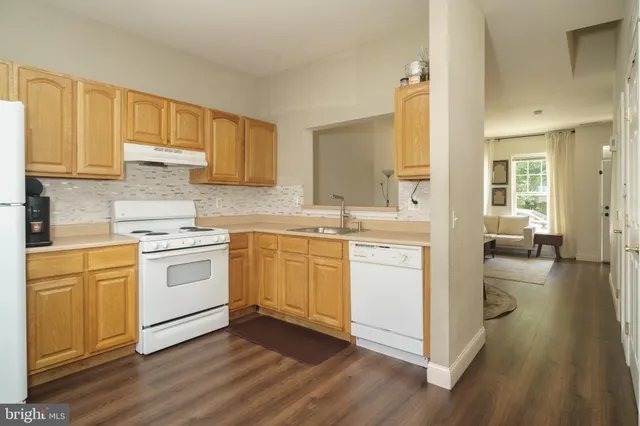 a kitchen with a white stove top oven sink and cabinets