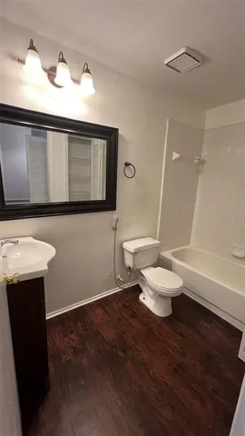 a bathroom with a toilet a sink and mirror