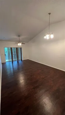 a view of a room with wooden floor fan and window