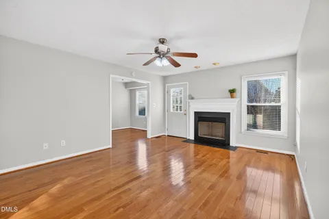 a view of a room with wooden floor and a ceiling fan