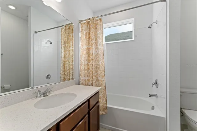 a bathroom with a granite countertop sink a mirror and a bathtub