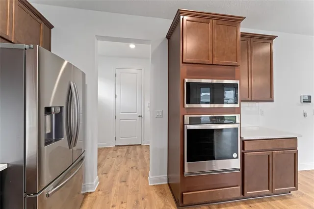 a kitchen with stainless steel appliances a refrigerator stove and cabinets