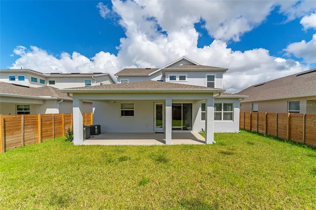 a view of a house with a yard balcony and large tree