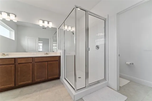 a spacious bathroom with a shower sink and mirror