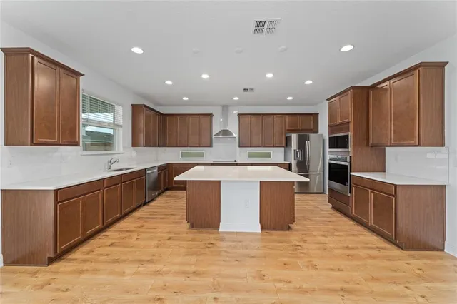a large kitchen with stainless steel appliances kitchen island granite countertop a stove sink and cabinets