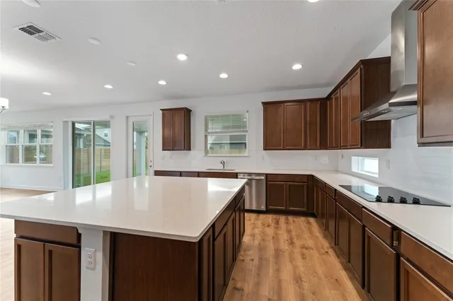 a kitchen with granite countertop a sink a counter top space stainless steel appliances and cabinets