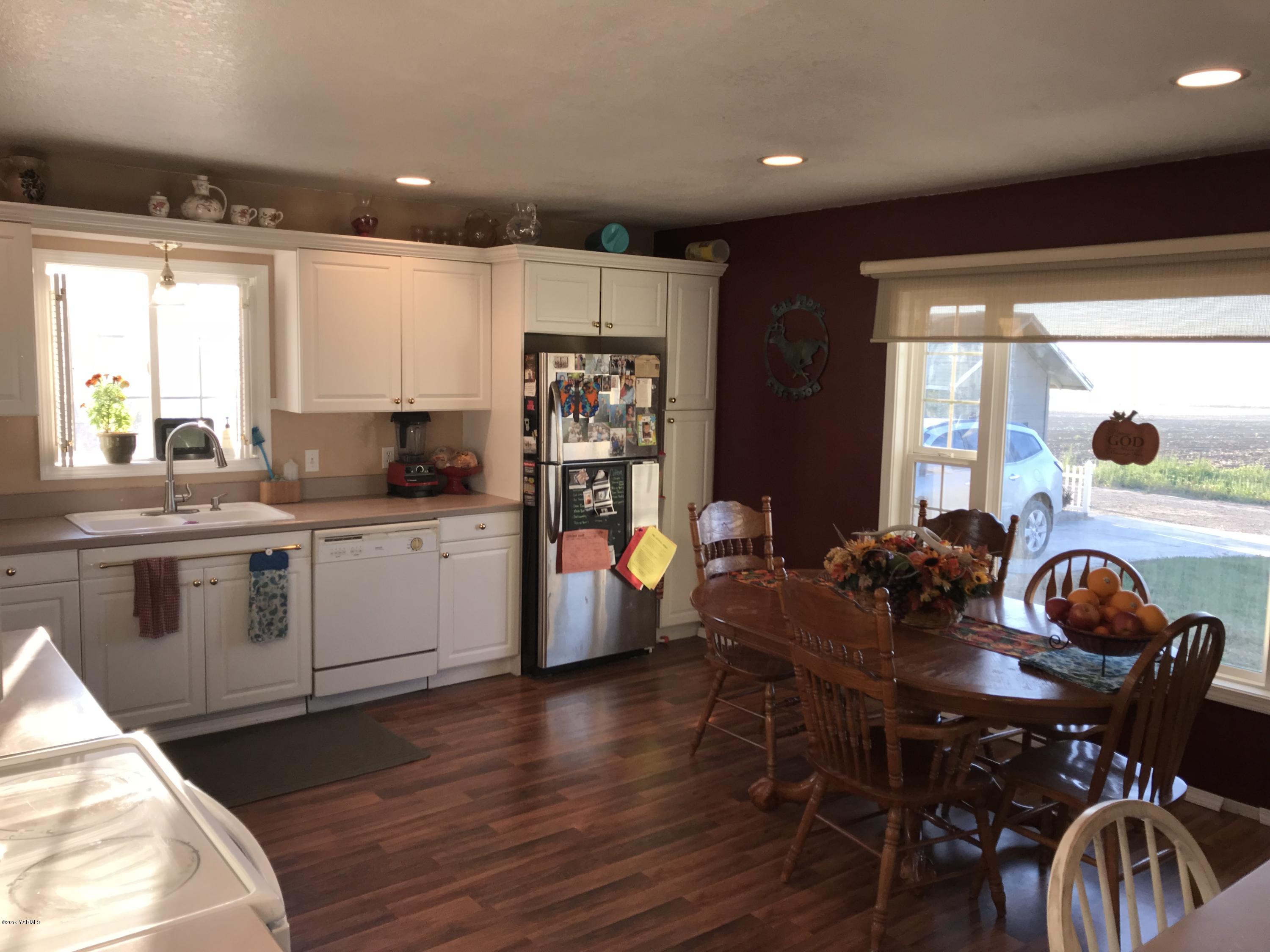 2551 Independence Road Outlook, WA 98938 - Photo 8 of 21 a kitchen with stainless steel appliances granite countertop a stove a sink a microwave a dining table and chairs with wooden floor