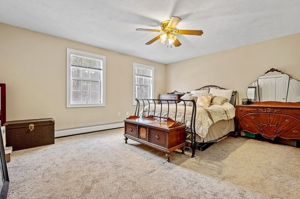 557 Cronin Road Warren, MA 01585 - Photo 12 of 28 a bedroom with a bed and a chandelier