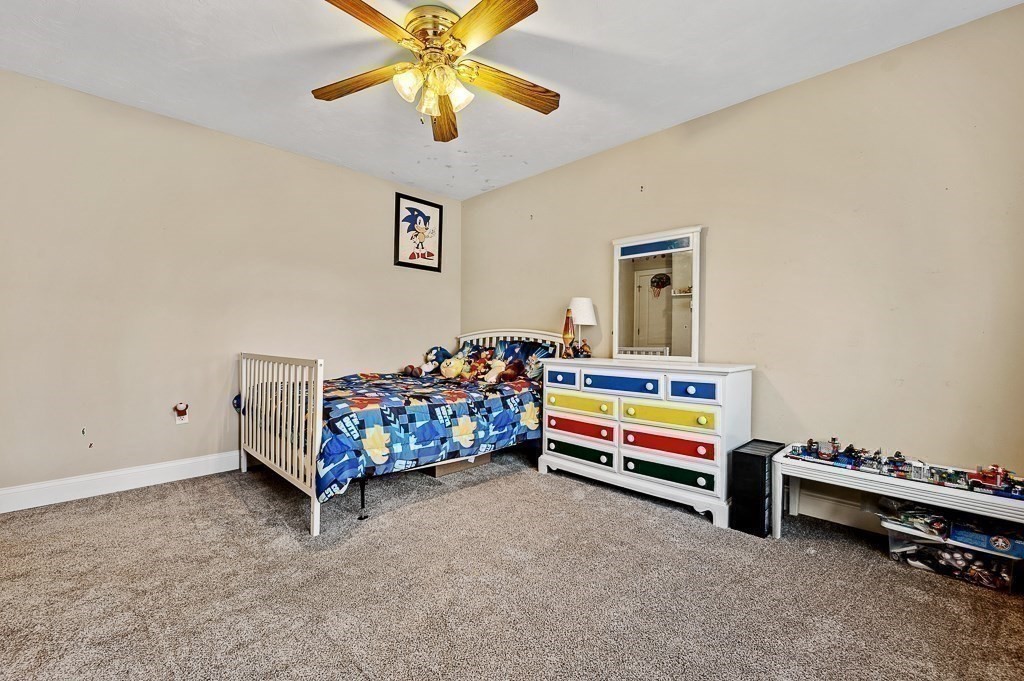 557 Cronin Road Warren, MA 01585 - Photo 15 of 28 a bedroom with bed and a chandelier