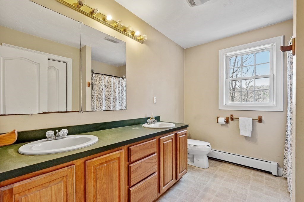 557 Cronin Road Warren, MA 01585 - Photo 17 of 28 a bathroom with a granite countertop sink and a mirror