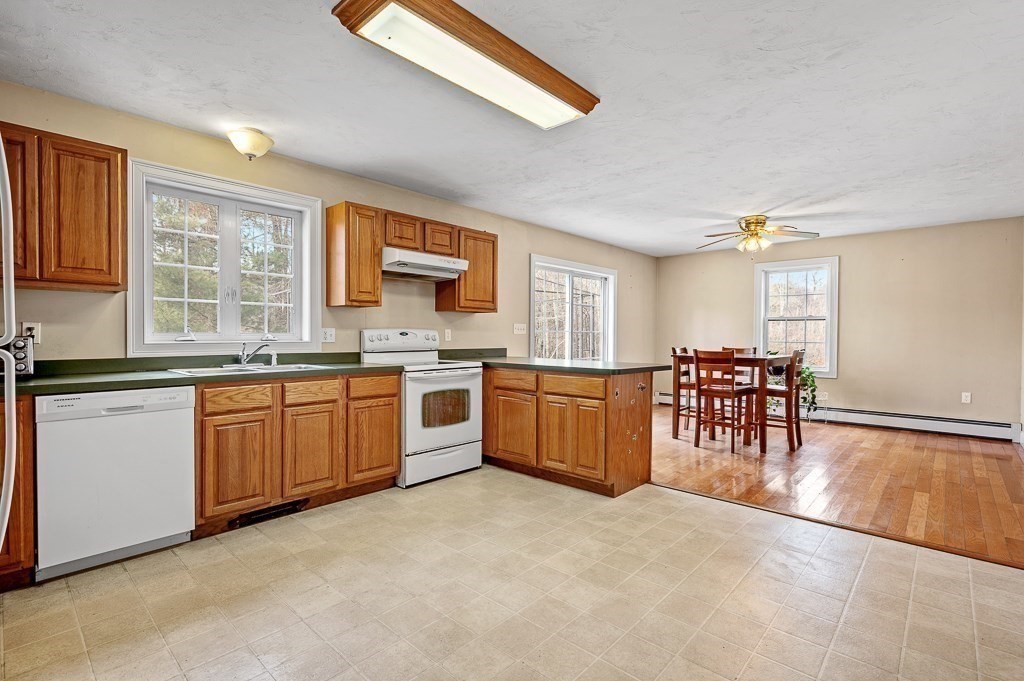 557 Cronin Road Warren, MA 01585 - Photo 5 of 28 a large kitchen with stainless steel appliances granite countertop a stove top oven a sink a dining table and chairs