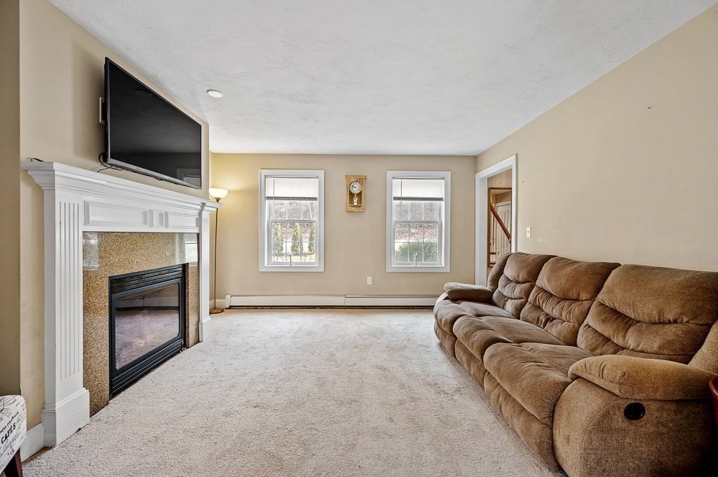 557 Cronin Road Warren, MA 01585 - Photo 8 of 28 a living room with furniture a flat screen tv and a fireplace