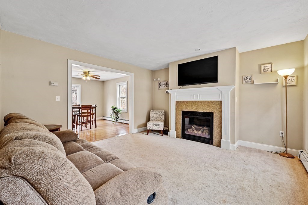 557 Cronin Road Warren, MA 01585 - Photo 9 of 28 a living room with furniture a flat screen tv and a fireplace