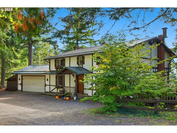 a view of a house with a large tree and a yard