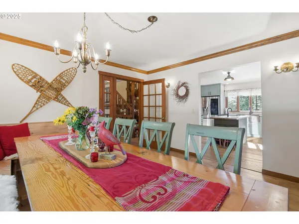 a dining room with furniture a chandelier and wooden floor
