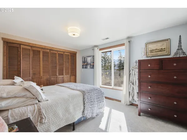 a bedroom with a large bed and a flat tv screen on dresser
