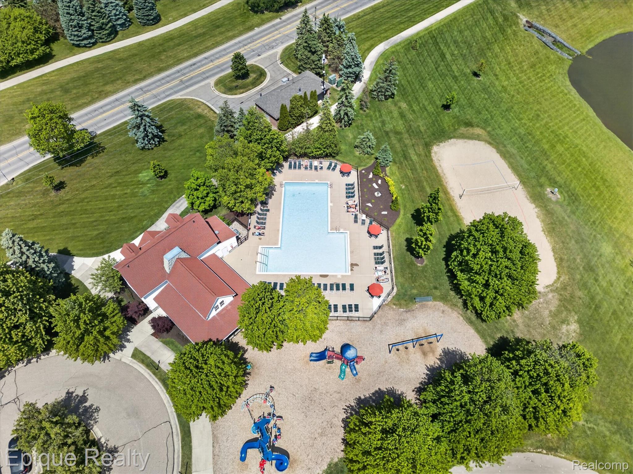 760 Caribou Court Rochester, MI 48307 - Photo 57 of 67 Community amenities featuring a large outdoor pool, clubhouse, sand volleyball court, and playground equipment