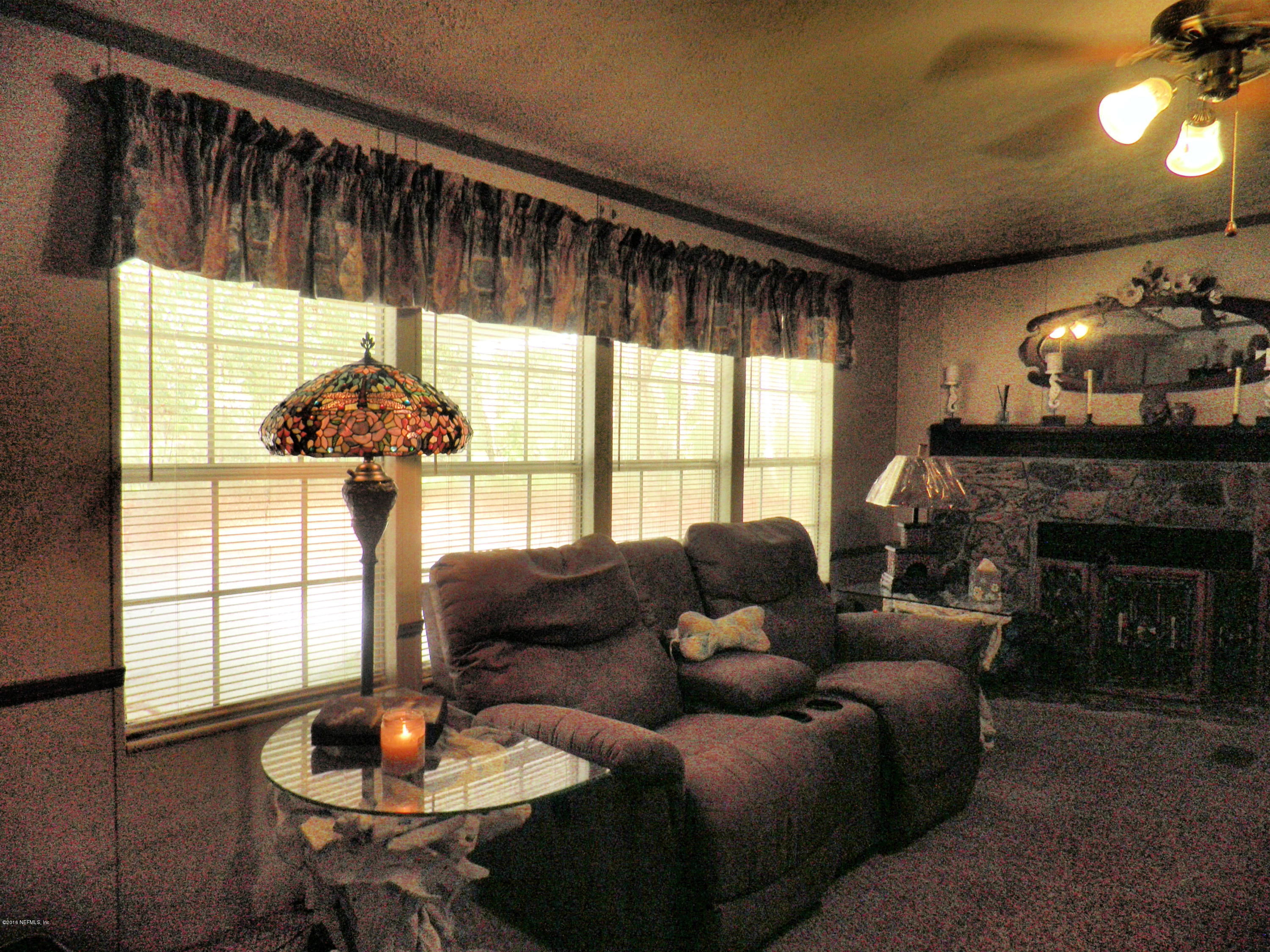 268 Beulah Church Road Welaka, FL 32112 - Photo 11 of 33 a living room with furniture a chandelier and a large window
