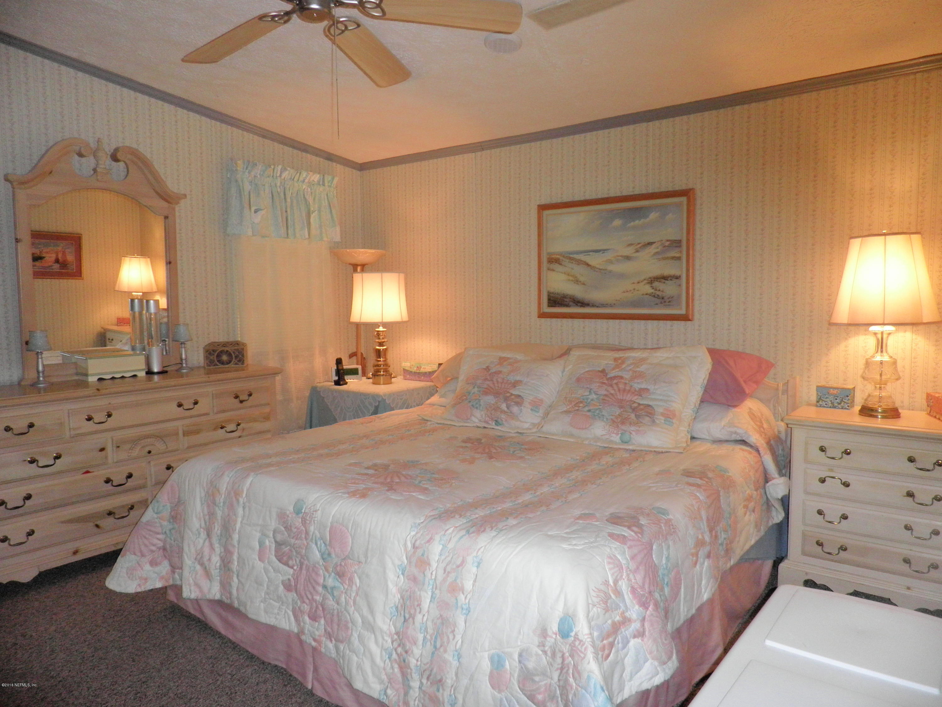 268 Beulah Church Road Welaka, FL 32112 - Photo 15 of 33 a bedroom with a bed and a lamp on dresser