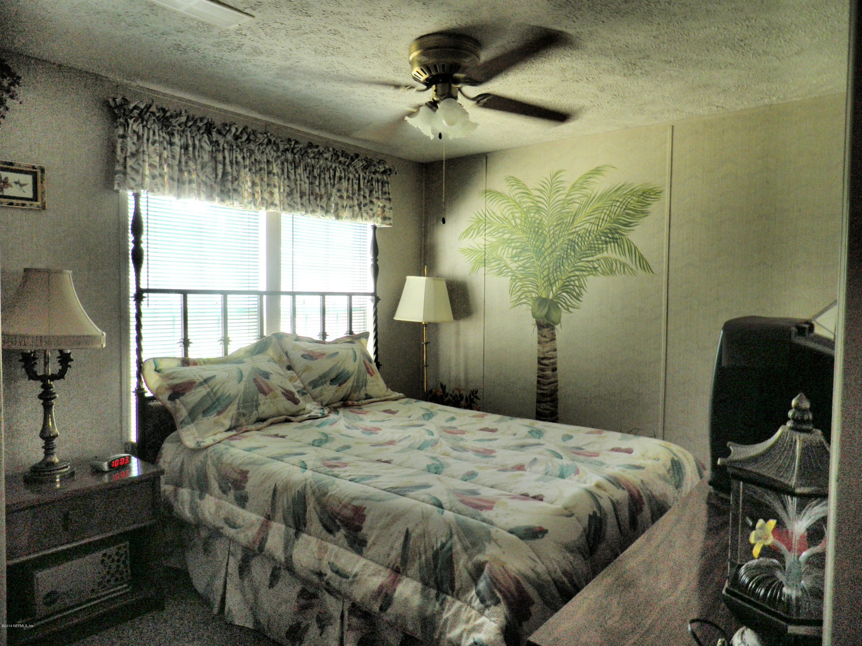 268 Beulah Church Road Welaka, FL 32112 - Photo 23 of 33 a bedroom with a bed and a chandelier